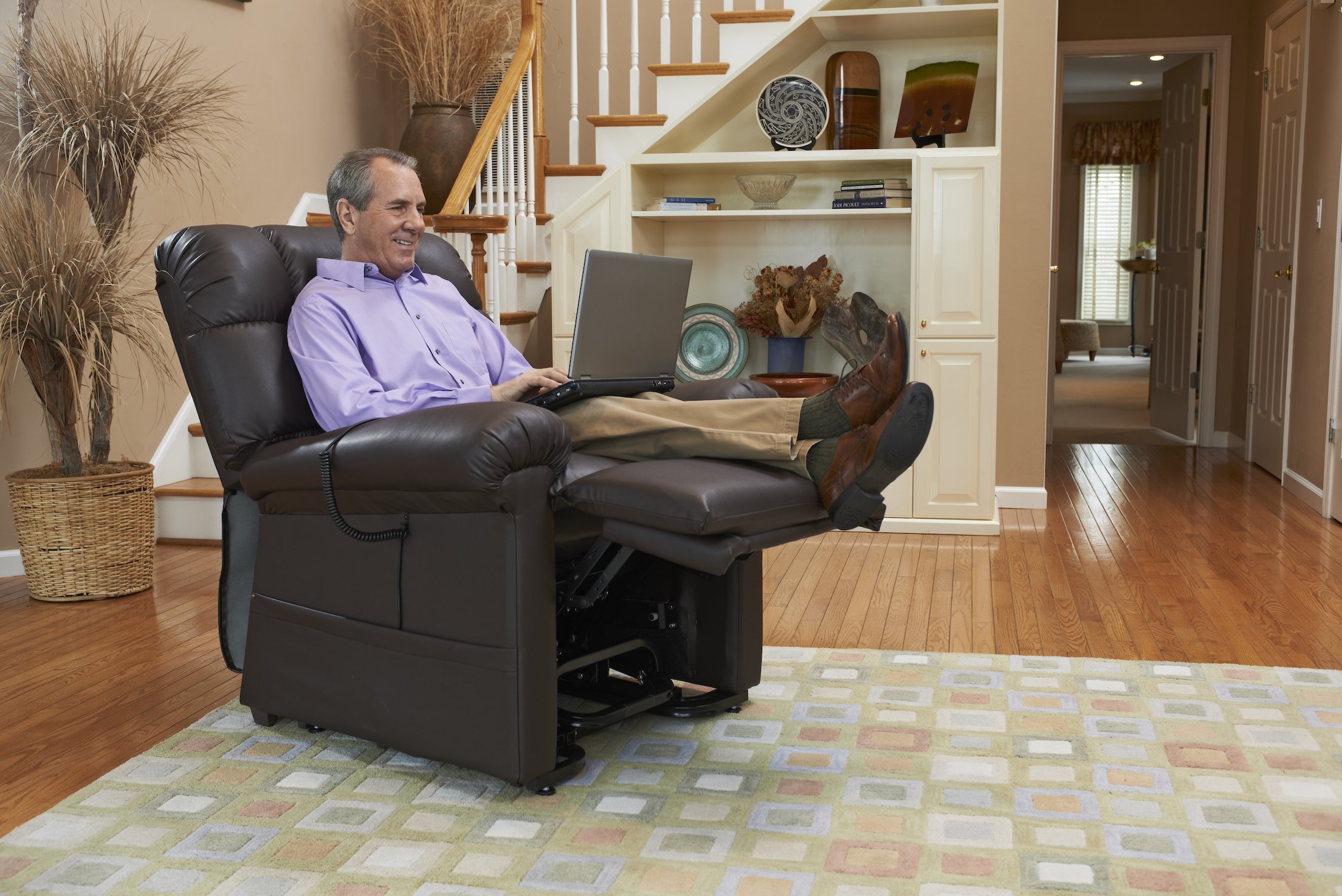 Man using a laptop while seated in a Golden Cloud lift chair